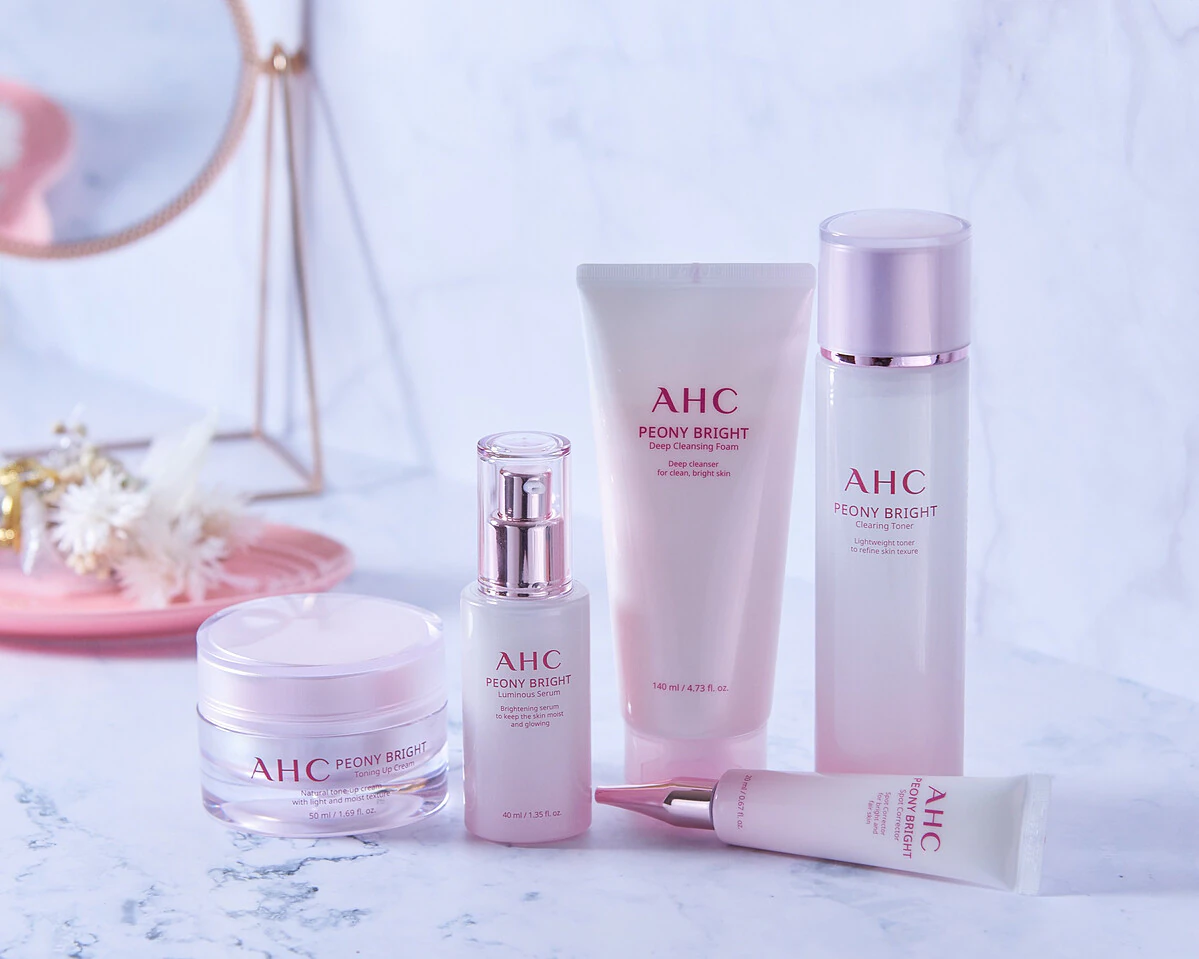 AHC Peony Bright skincare products on a marble surface